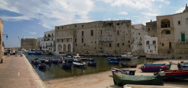 Monopoli, İtalya. 06 28 2019. Monopoli limanına demir atmış balıkçı tekneleri. İskeleye demirlemiş ya da iskeleye kenetlenmiş eski limanın panoramik manzarası..