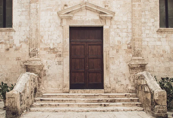 チエサSs ピエトロとパオロ イタリア語で聖ペテロと聖パウロ教会 モノポリ イタリア 気象条件によって古い石で教会への入り口のドア — ストック写真