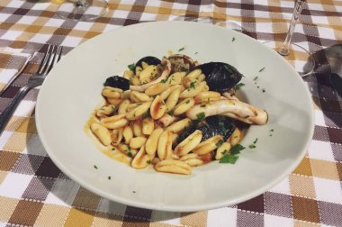 Monopoli, İtalya 'da bir restoranda deniz ürünleri ile Cavatelli. Cavatelli, Molise bölgesinden yuvarlak kenarlı bir kapsül şeklinde kuru yumurtasız makarna türüdür..