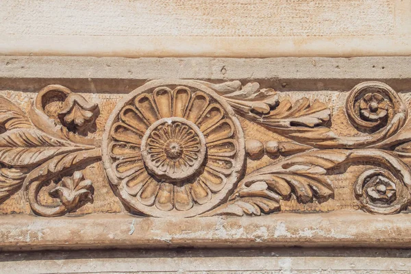 Relief on the facade of an old house in Aldo Moro square in Locorotondo, Italy. Renaissance decoration engraved in the stone and weathered by time.