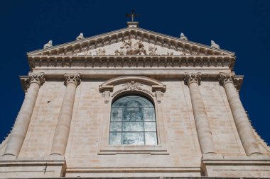 Facade of the mother church of San Giorgio Martire in Locorotondo, Italy. Facade, in neoclassical style from the 16th century, has a relief of Saint George with the dragon on the tympanum.