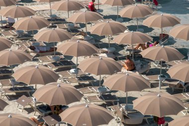 Lecce, Italy. 06 29 2019. Torre dell Orso beach full of tourists to take a bath or sunbathe. The beach lined with umbrellas to protect from the harsh summer sun.