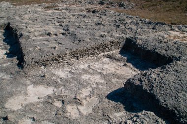 Soil excavated and molded into the limestone rock. Stone structure at the Roca Vecchia archaeological site in Lecce, Italy.