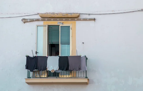 Clothes hanging in the window of a house in Gallipoli, Italy. Clothes drying in the sun on the clothesline typical of southern Italy.