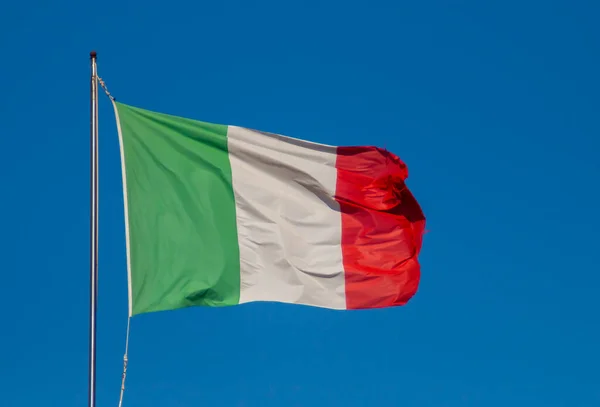 Flag of Italy blowing in the wind in Gallipoli, Italy. Flag with a blue sky in the background on a bright summer day.