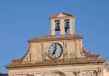 İtalya, Lecce 'deki katedral meydanında Başpiskoposun sarayı. Çan kulesinin iki çanı ve saatli barok mimari detayları..