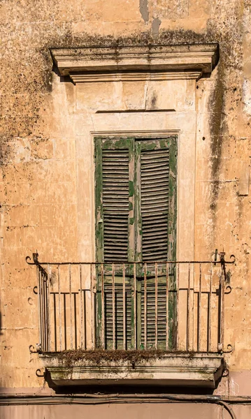 イタリアのレッチェの狭い通りにある古いバルコニー 気象条件や無視によって引き起こされる摩耗は シャッター上の塗料に反映されます — ストック写真