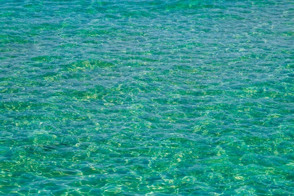 砂の海底透明な水を介して イタリアのオトラントで 水の表面に潮風の波紋を通して白い砂浜の底 — ストック写真