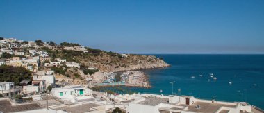 İtalya 'nın Lecce kentindeki Castro marinasının manzarası. Tekneler rıhtıma yanaştı ve yakınlarda demirledi. Limanda güneşleniyor..