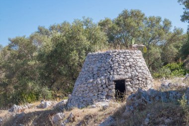 Trullo, İtalya 'nın Gagliano del Capo kentindeki bir zeytinlikte geleneksel kuru taş kulübe. Koni şekli, özellikle de çatısı, bu yapının en temsili özelliğidir..