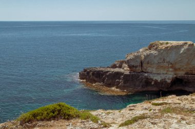 Santa Maria di Leuca 'daki kireçtaşı kayalıkları, Apulia, İtalya. Adriyatik Denizi ve İyon Denizi 'nin kristal berrak turkuaz sularının ayrıldığı pelerin..