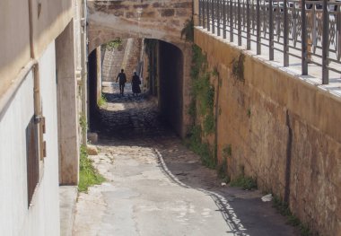 Polignano a Mare, İtalya 'daki Borbonico köprüsünün yanındaki dar sokakta. Lama Monachile Koyu sahiline ulaşmak için kaldırımlı cadde..