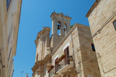 İtalya, Polignano a Mare 'deki Araf Papaz Kilisesi' nin çan kulesi. Güneşli bir yaz gününde şehrin tarihi kısmının dar sokakları arasında yer alan kilise..