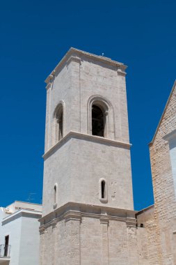 İtalya, Polignano a Mare 'deki Saint Mary Assunta Kilisesi' nin çan kulesi. Güneşli bir yaz gününde şehrin tarihi kısmının dar sokakları arasında yer alan kilise..