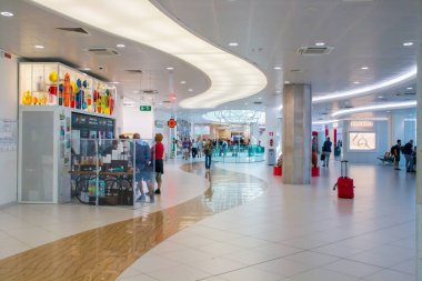 Bari, İtalya. 07 04 2019. Bari-Palese havaalanı, Aeroporto Internazionale di Bari-Karol Wojtyla. Terminalin bekleme odasındaki koltuklar, dükkanlar ve yolcular..