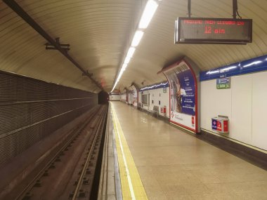 Madrid İspanya. 08: 30 2019. Tribunal metro istasyonu, Tres Olivos istasyonuna doğru 10. hat. Aydınlatma işareti olan boş platform 12 dakikalık bekleme süresi.