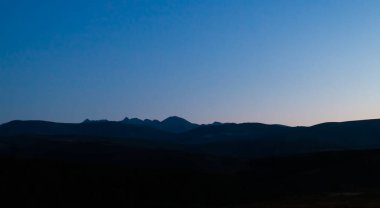 İspanya, Avila 'daki Hoyos del Espino' dan Sierra de Gredos 'un kuzey tarafının alacakaranlık görüntüsü. Gredos Sirki 'nin oluşumunun zirvelerinin silueti, Almanzor Tepesi yüksekliğine dikkat çeker..