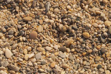 Sahilde birikmiş çakıl taşlarının arka planı. Almerya, Endülüs, İspanya sahillerinin renkli mezarlarının kompozisyonu.