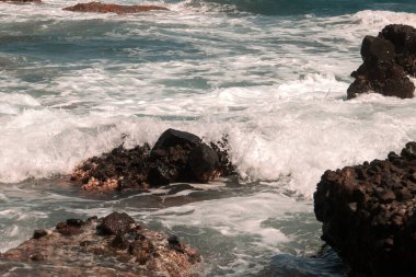 Deniz dalgaları kıyıya yakın kayalarda kırılıyor. Nijar, Almerya, İspanya 'daki Los Amarillos Koyu' nda Akdeniz.