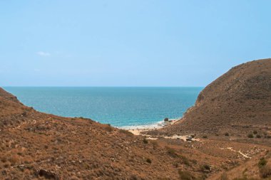 Nijar, Almerya, İspanya 'daki Enmedio Koyu' na giden Agua Amarga Patikası. Yazın çalı ve çöl bitkilerinin arasından dik iniş yolu..