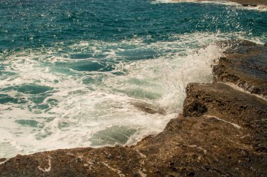 Deniz dalgaları kıyıya yakın kayalarda kırılıyor. Nijar, Almerya, İspanya 'daki Enmedio Koyu' nda Akdeniz.