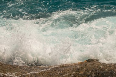 Deniz dalgaları kıyıya yakın kayalarda kırılıyor. Nijar, Almerya, İspanya 'daki Enmedio Koyu' nda Akdeniz.