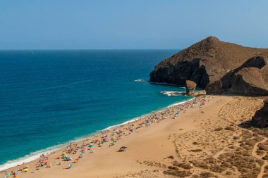 Los Muertos sahilinde güneşleniyor, Carboneras, Almeria, İspanya. Güneşli bir yaz gününde turkuaz sularıyla Akdeniz kıyılarındaki plajın en üst manzarası..