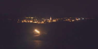 Şehrin gece panoramik görüntüsü, El Granado, Huelva, Endülüs, İspanya. Şehir sokakları, merkezde kilise çan kulesi olan belediyenin sokak lambalarıyla aydınlanıyor..