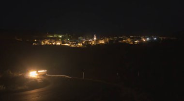 Şehrin gece panoramik görüntüsü, El Granado, Huelva, Endülüs, İspanya. Şehir sokakları, merkezde kilise çan kulesi olan belediyenin sokak lambalarıyla aydınlanıyor..