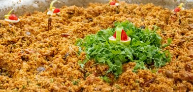 Büyük bir paella tavasında hazırlanmış av eti ile pilav. Sebzeli, yaban domuzlu ve geyik etli kuru pirinç tabağı. San Silvestre de Guzman, Huelva, İspanya.