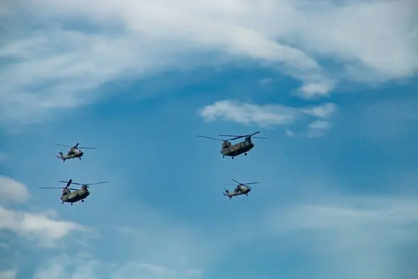 Stock image Two Boeing CH-47 Chinook heavy transport and two Eurocopter EC-665 Tiger from the Army. Military and emergency services helicopters flying at the Columbus Day military parade in Madrid, Spain.