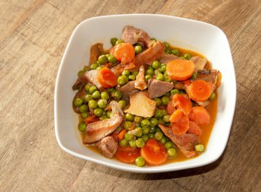 Bir kase hindi yahnisi, bezelye ve yaban mantarı. Malzeme olarak havuç, bezelye, soğan, safran süt kaskı ve hindi eti içeren sağlıklı yemek tarifi. Madrid İspanya.