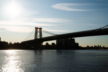 Williamsburg Köprüsü 'nün silueti New York, ABD' deki Manhattan sahilinden şafakta. John V. Lindsay East River Park 'tan görüntüler. 9 Kasım 2019.