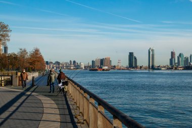 New York 'ta East River' da balık tutan bir adam. Doğu Houston Caddesi 'nin sonundan Doğu Nehri manzarası. Manhattan sahilinden Doğu Nehri 'ne dolaş. New York.