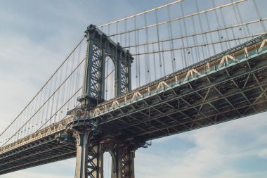 Aynı isimdeki adanın kıyısından Manhattan Köprüsü. Fotoğraf, Manhattan 'a en yakın sütunun altından çekildi. Doğu Nehri kıyısında. New York, ABD, 2019.