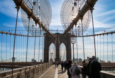 New York, ABD. 11 09 2019. İnsanlar Brooklyn Köprüsü 'nü yaya bölgesinden geçiyorlar. Soğuk bir sonbahar sabahında şehir manzarası. Arka planda Brooklyn 'in binaları Doğu Nehri' nin kıyısında..