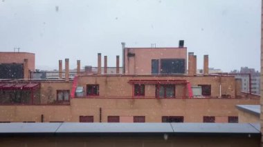 Modern binaların çatılarına kar yağıyor. Madrid, İspanya 'da bahar fırtınasında kar yağıyor. 03 27 2020.
