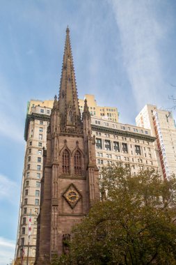 Manhattan, New York, ABD 'de 89 Broadway' deki Trinity Kilisesi. Gotik Diriliş tarzı çan kulesi finans bölgesinin gökdelenleriyle çevrili..