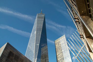 New York, ABD 'nin finans bölgesinde gökdelenleri olan şehir manzarası. One World Trade Center gökdeleni ve sağında Four WTC alçak açılı ve açık gökyüzü. Sonbahar 2019.