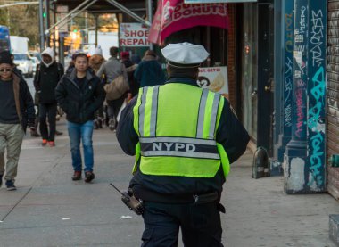 New York, ABD. 11 09 2019. Şehrin kaldırımında yürüyen bir polis memurunun arkası. Şehirdeki yayalar ve iş yerlerinin arasında Grand Street 'te polis yürüyor.
