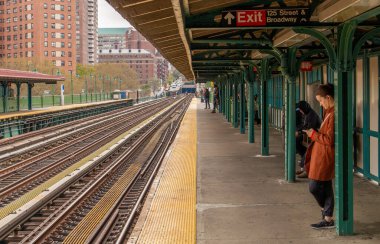New York, ABD. 11 10 2019. Harlem 'deki metro platformu, Manhattan, New York. Broadway caddesindeki köprüdeki metro istasyonunda W 125 sokağının kesiştiği yerde insanlar var..