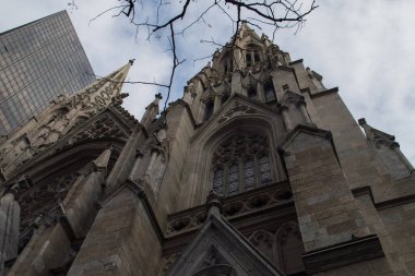St. Patrick Katedrali 'nin girişi, New York, Manhattan, ABD. Rockefeller Center 'daki bir gökdelenin yanındaki neo-gotik cephenin alçak açılı görüntüsü.