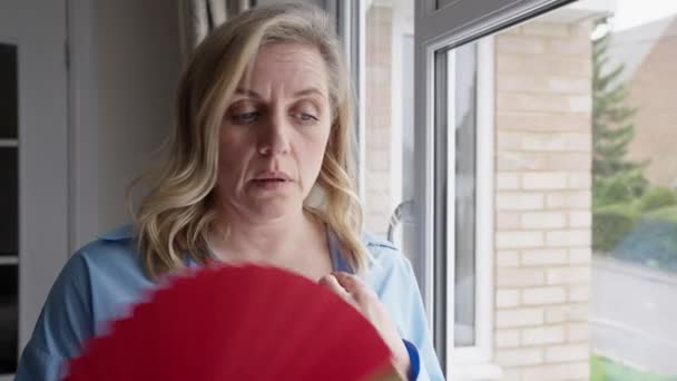Menopozlu Olgun Kadın Elinde Kağıt Yelpaze Ile Evde Sifonu Çekiyor — Stok video