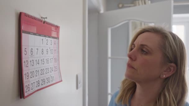 记性差的月经期成熟妇女在家看日历 — 图库视频影像
