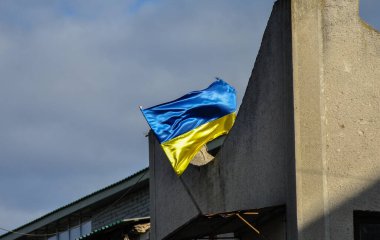 Ukrayna bayrağı rüzgarda dalgalanan eski bir binanın üzerinde