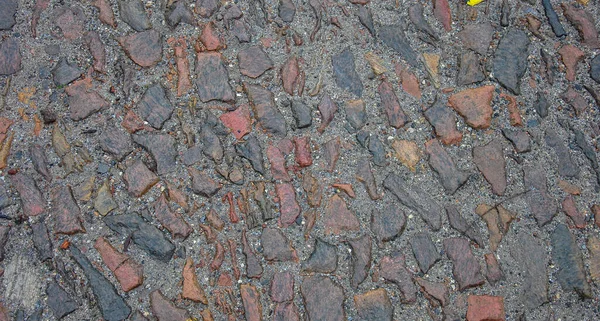 background of granite wet stones. wet cobblestone road.