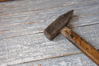 Eski bir çekiç eski püskü bir boyayla ahşap bir masada