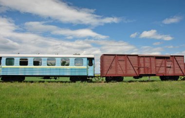 Kırsaldaki eski dar bir demiryolu treninin yolcu ve yük vagonu