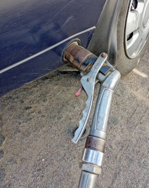 Bir arabaya sıvılaştırılmış petrol gazı doldurmak. Yakıt ikmali tabancasını yakın tut.