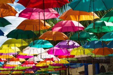 Colorful umbrellas spanning pedestrian street at Caudan Waterfront shopping center, Port Louis, Mauritius
